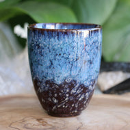 Handmade ceramic tea cup with blue reactive glaze handleless