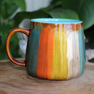 Handmade ceramic mug blue interior with orange yellow brushed glaze