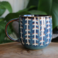 Handmade ceramic mug with blue and white glaze detailing boho style