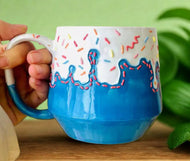 Handmade ceramic mug thats blue with rainbow sprinkles