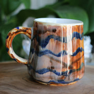Brownish orange Handmade ceramic mug with blue wavey stripes