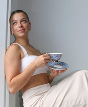 Load image into Gallery viewer, Model Holding our Elegant purple bone china tea cup and saucer with gold-coloured detailing